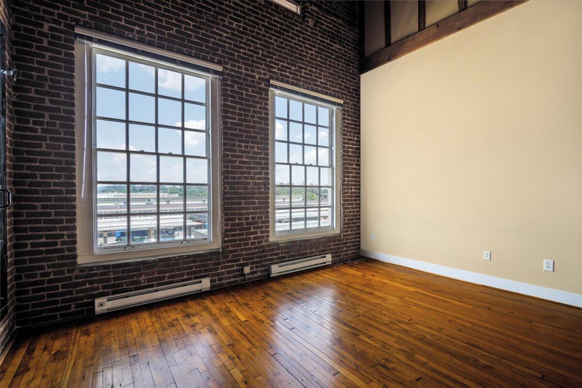 324 Salem Avenue Southwest, Unit 303 Roanoke, VA 24016 - Photo 4 of 21 an empty room with wooden floor and windows