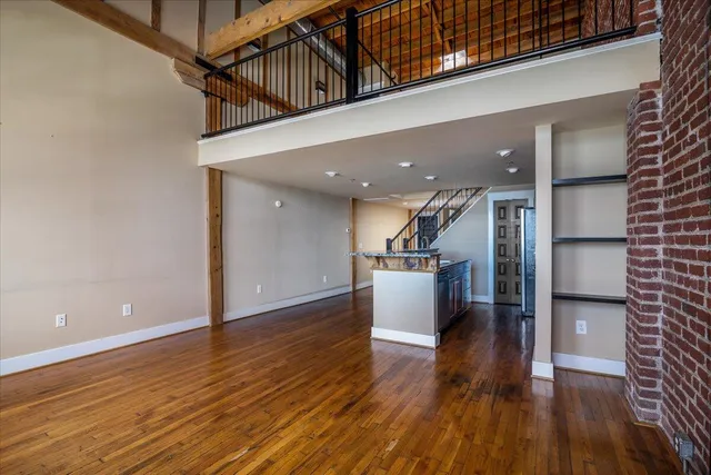 a view of a hallway with wooden floor and staircase
