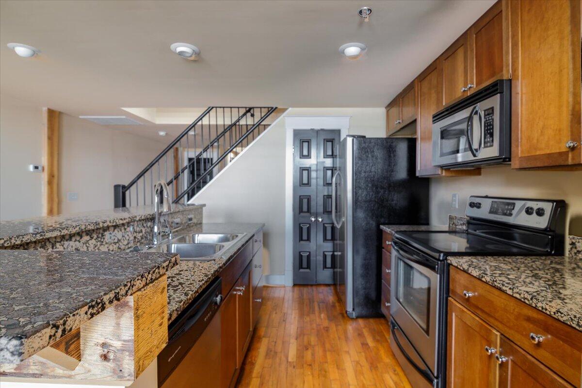 324 Salem Avenue Southwest, Unit 303 Roanoke, VA 24016 - Photo 6 of 21 a kitchen with granite countertop a sink a counter top space stainless steel appliances and cabinets