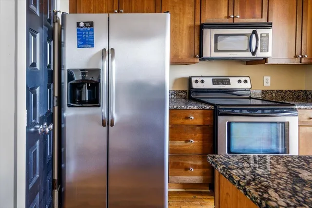 a kitchen with stainless steel appliances granite countertop a refrigerator and a stove