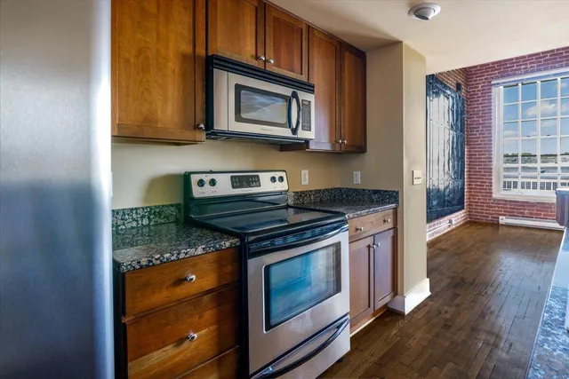 a kitchen with stainless steel appliances granite countertop a stove microwave and cabinets