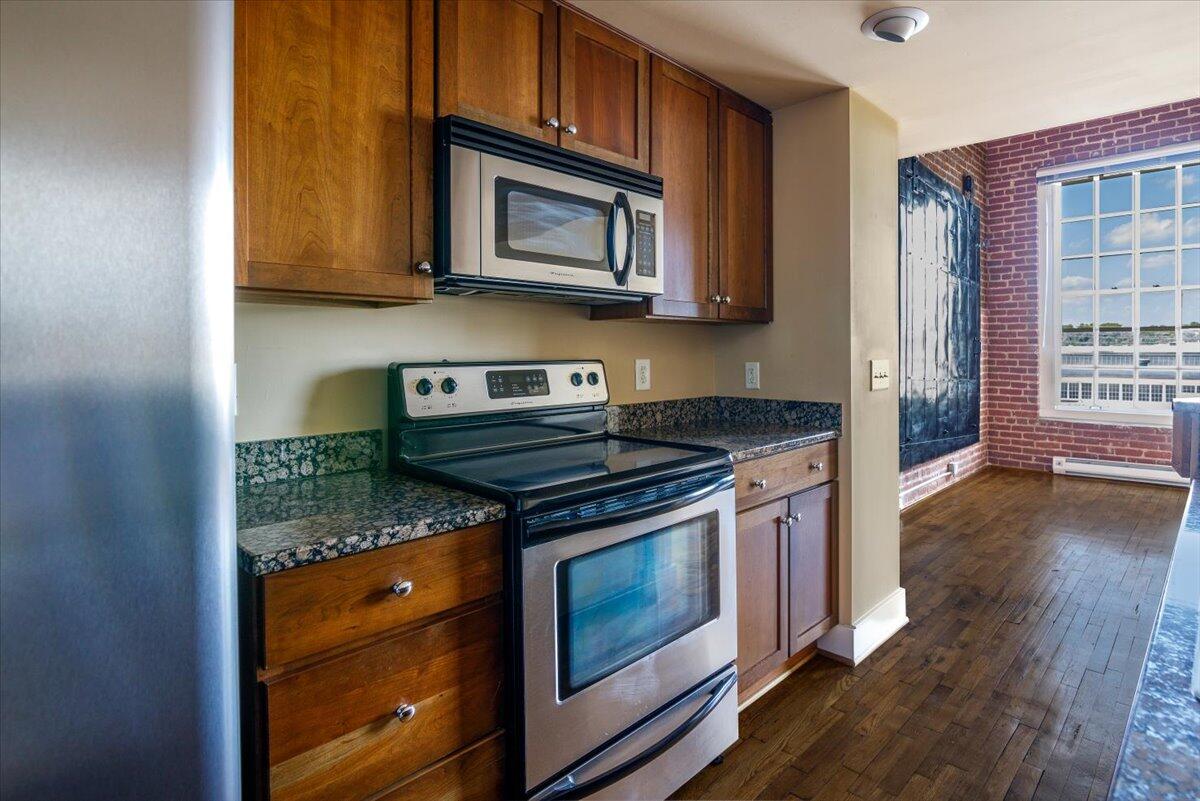 324 Salem Avenue Southwest, Unit 303 Roanoke, VA 24016 - Photo 9 of 21 a kitchen with stainless steel appliances granite countertop a stove microwave and cabinets