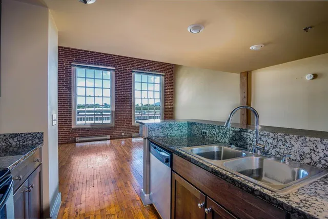 a kitchen with granite countertop a sink and a stove