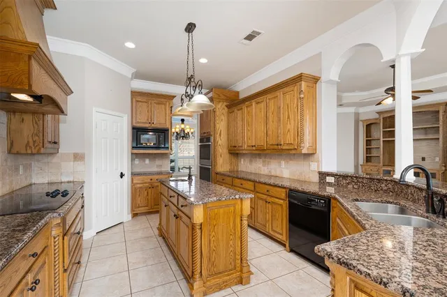 a kitchen with kitchen island granite countertop a sink cabinets and stainless steel appliances