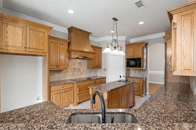 a kitchen with stainless steel appliances granite countertop a stove and a white cabinets