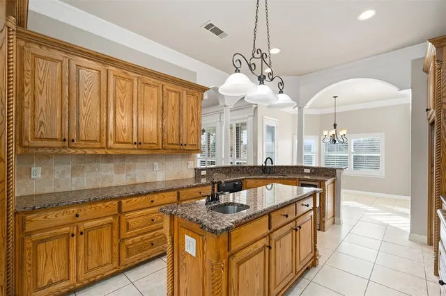 a dining room with wooden floor a chandelier a wooden table and chairs