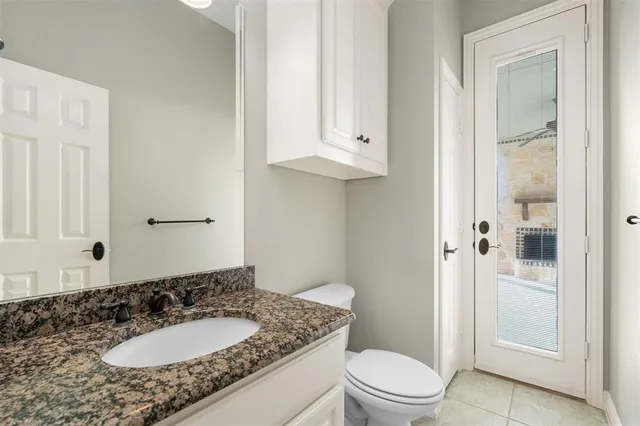an empty room with chandelier fan and windows