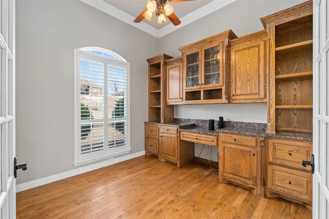 a dining room with wooden floor a chandelier a wooden table and chairs