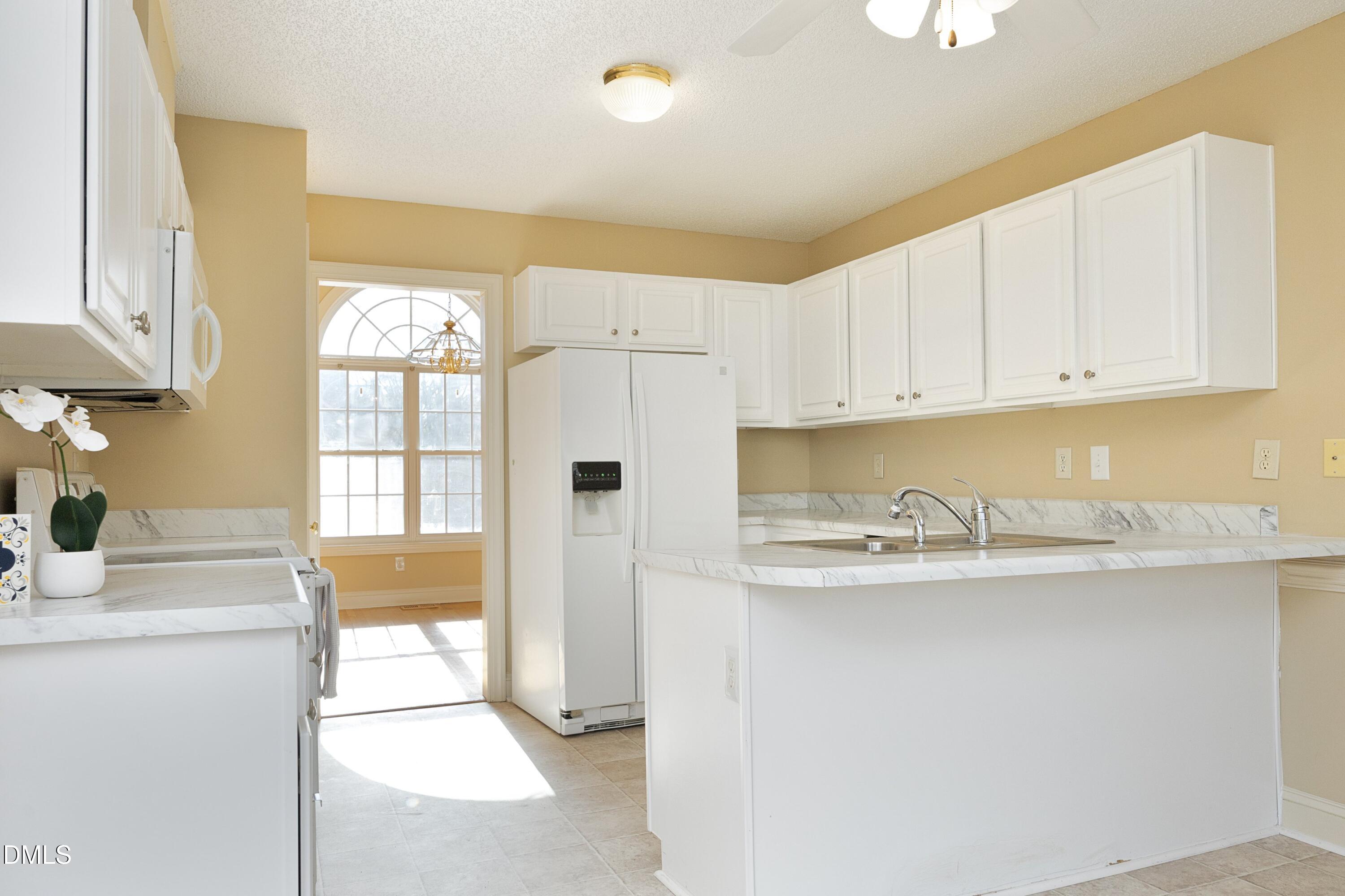 103 Brims Way Garner, NC 27529 - Photo 13 of 36 a kitchen with granite countertop a sink and white cabinets