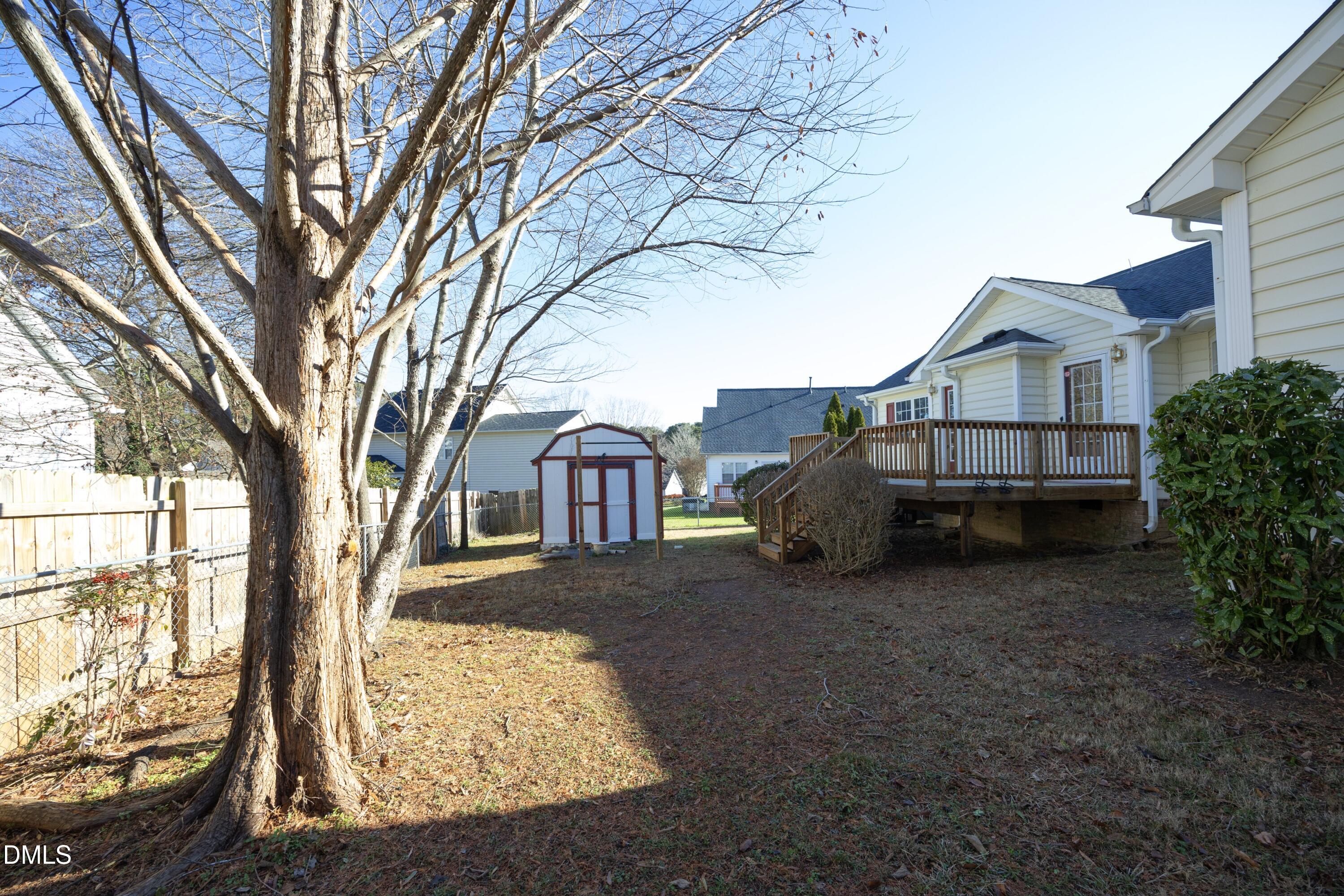 103 Brims Way Garner, NC 27529 - Photo 31 of 36 a view of a house with a large tree and wooden fence