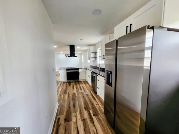 a kitchen with a refrigerator and a stove top oven