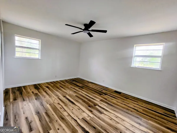 a view of a room with wooden floor and windows