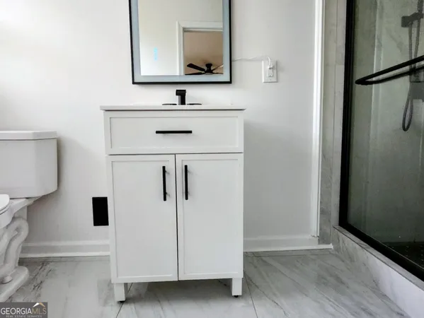 a bathroom with a sink a toilet and mirror