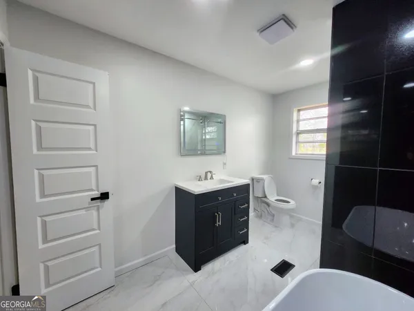 a bathroom with a toilet sink and mirror