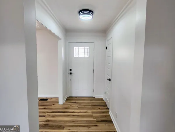 a view of a hallway to a bedroom with wooden floor