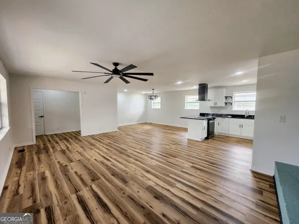 a view of empty room with wooden floor