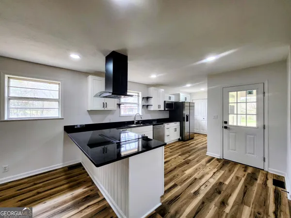 a kitchen with kitchen island granite countertop lots of counter top space and stainless steel appliances