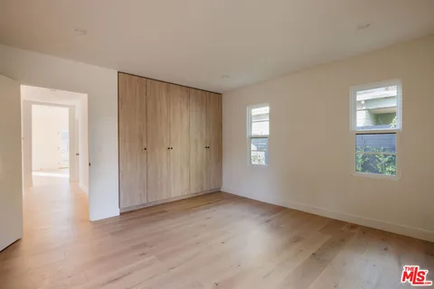 a view of empty room with closet and wooden floor