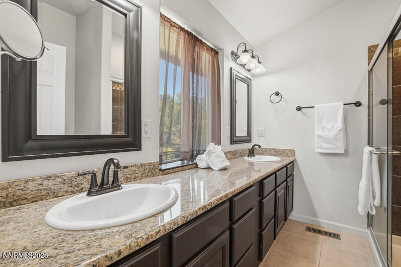 1367 Calavaras Road Reno, NV 89521 - Photo 11 of 26 a bathroom with a granite countertop sink and a mirror