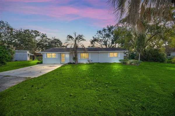 a front view of a house with a garden and yard
