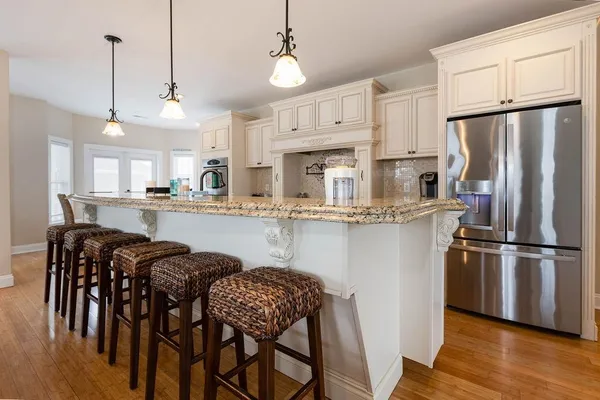 a living room with furniture kitchen view and a chandelier