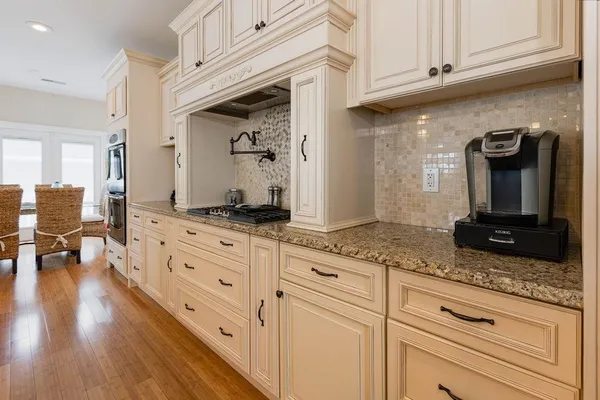 a living room with furniture kitchen view and a chandelier