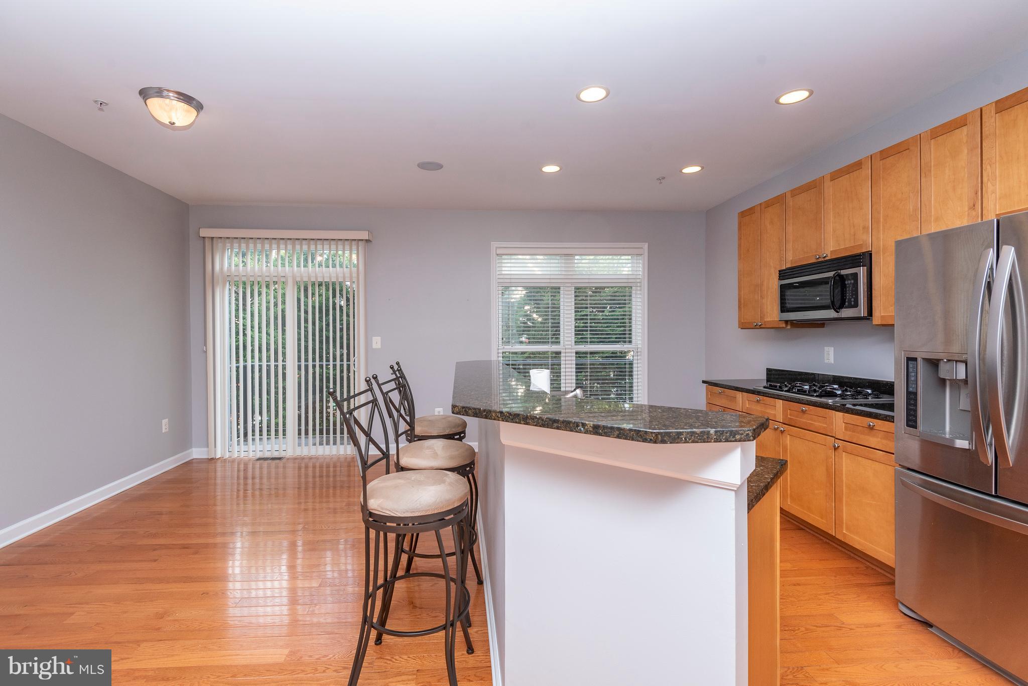 1510 Stack Street Baltimore, MD 21230 - Photo 10 of 32 a kitchen with stainless steel appliances granite countertop a stove a sink a microwave a refrigerator white cabinets and wooden floor