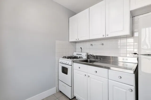 a kitchen with granite countertop white cabinets and white appliances