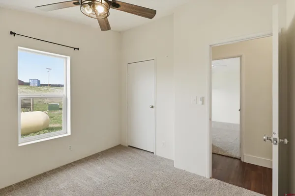 a view of an empty room with window and wooden floor
