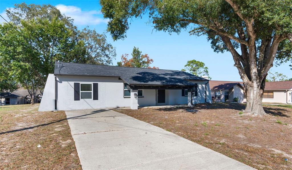 6503 Grapewood Road Spring Hill, FL 34609 - Photo 1 of 1 a view of a house with a yard and large tree