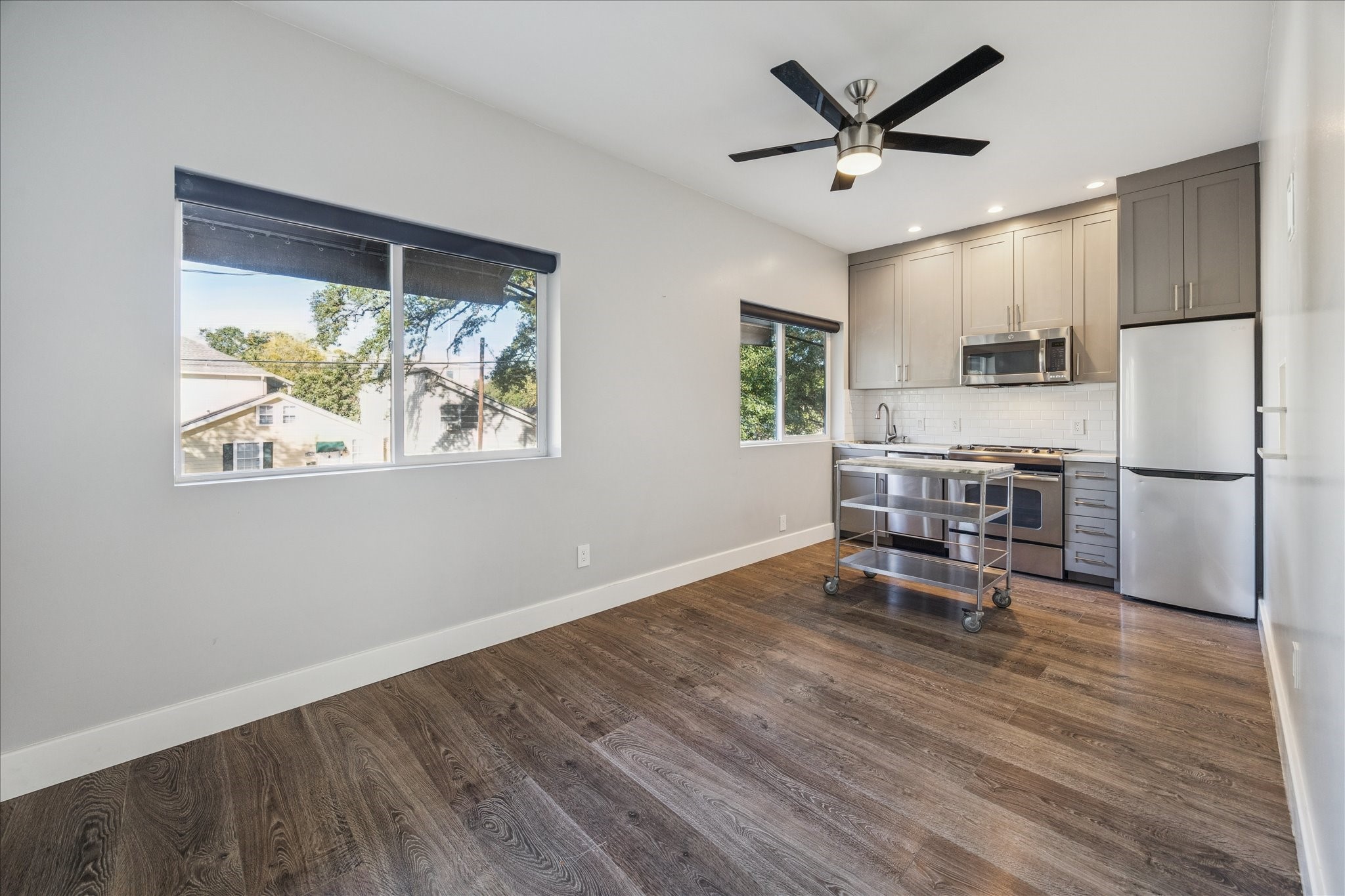 1919 Missouri Street Houston, TX 77019 - Photo 15 of 27 a kitchen with stainless steel appliances granite countertop a refrigerator a stove a microwave oven with a dining table and chairs with wooden floor