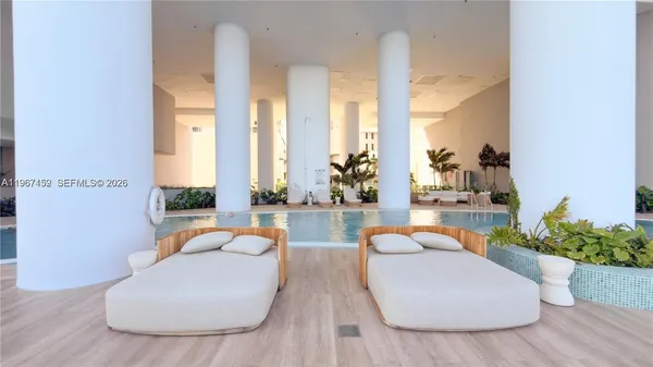 a view of patio with chairs and table under an umbrella