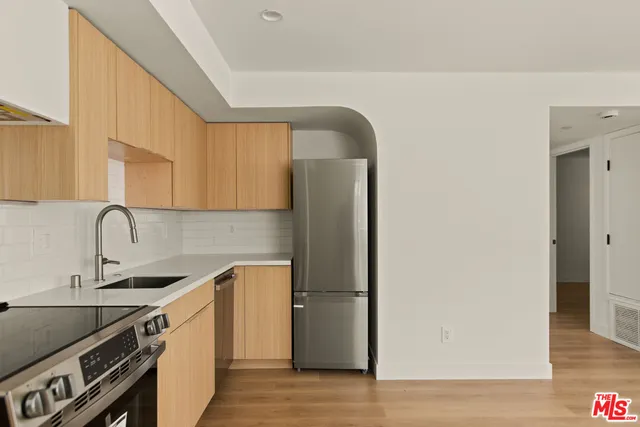 a kitchen with a sink cabinets stainless steel appliances and a window