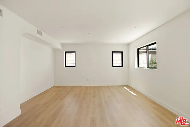 a view of a room with wooden floor and windows