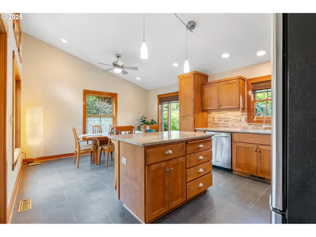 a kitchen with kitchen island granite countertop a sink cabinets and window