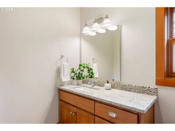a bathroom with a granite countertop sink and a mirror