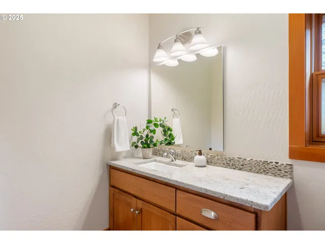 a bathroom with a granite countertop sink and a mirror