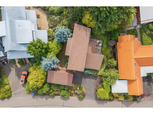 an aerial view of a house with a yard and tennis court