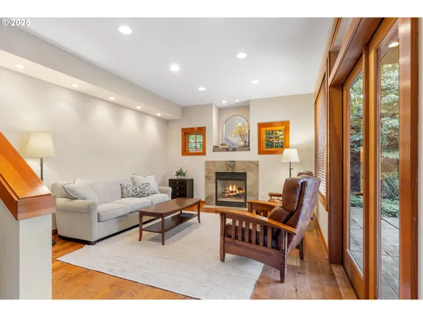 a living room with furniture a fireplace and a large window