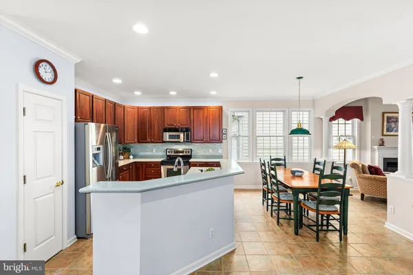 a view of a dining room with furniture a kitchen and chandelier