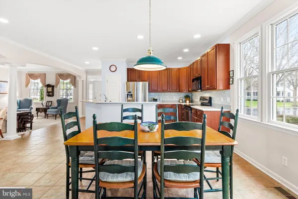 a kitchen with stainless steel appliances granite countertop a kitchen island a table and chairs
