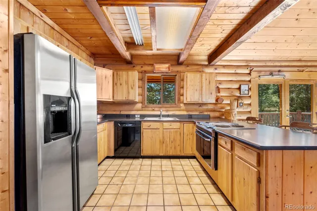 a kitchen with stainless steel appliances granite countertop a sink a stove a refrigerator and cabinets