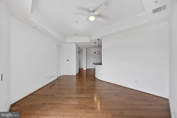 a view of an empty room with a window and wooden floor