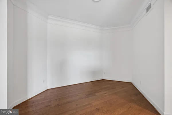 a hallway with wooden floor and windows