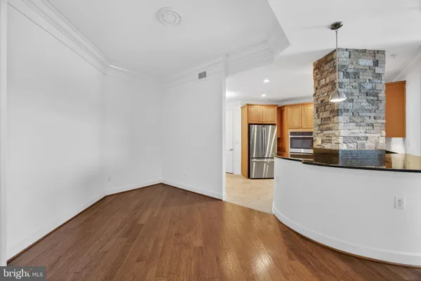 a kitchen with stainless steel appliances granite countertop a refrigerator a stove and a sink with wooden cabinets