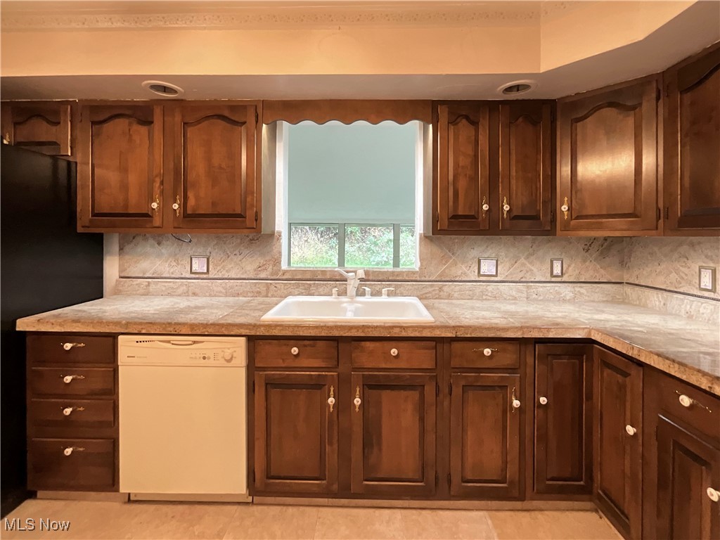 6568 Wylie Ridge Road New Cumberland, WV 26047 - Photo 5 of 28 Kitchen with black refrigerator, dishwasher, sink, and decorative backsplash