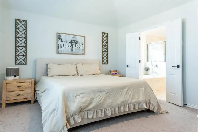 a bedroom with a bed and a painting on the wall