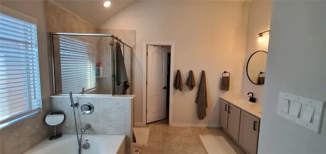 a bathroom with a tub sink and mirror