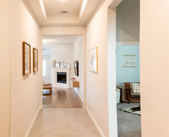 a view of a hallway with furniture and a kitchen view