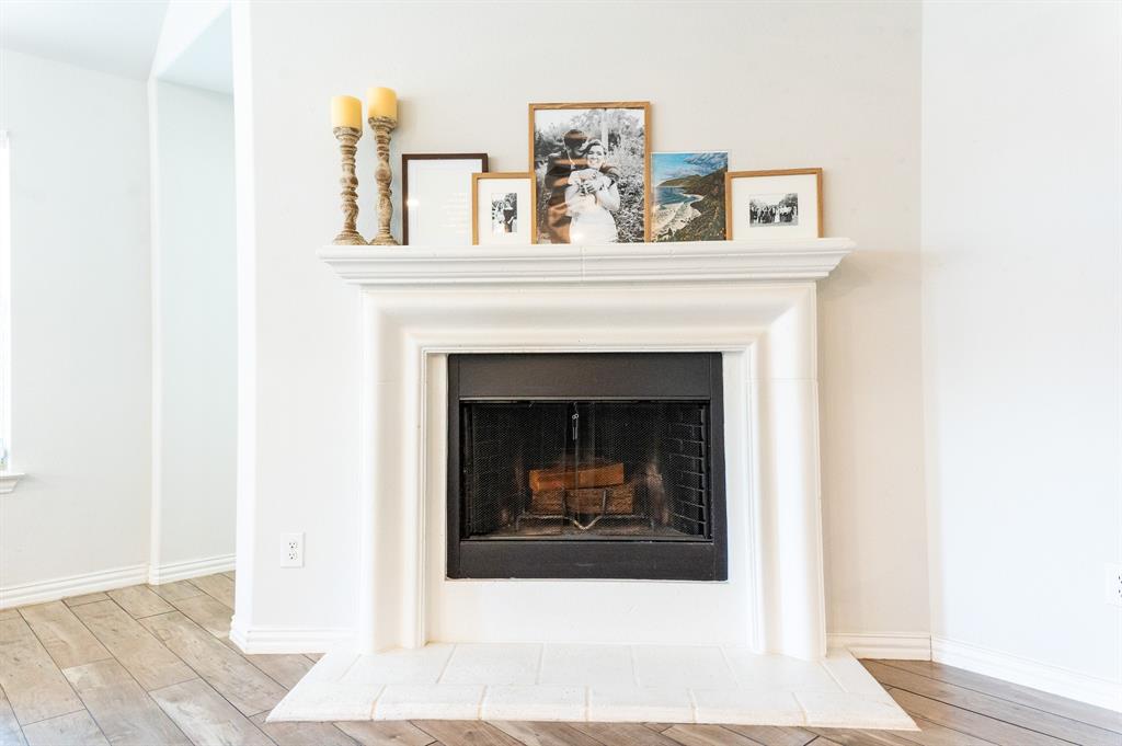 416 Windy Knoll Road Fort Worth, TX 76028 - Photo 6 of 34 a living room with a fireplace and wooden floor